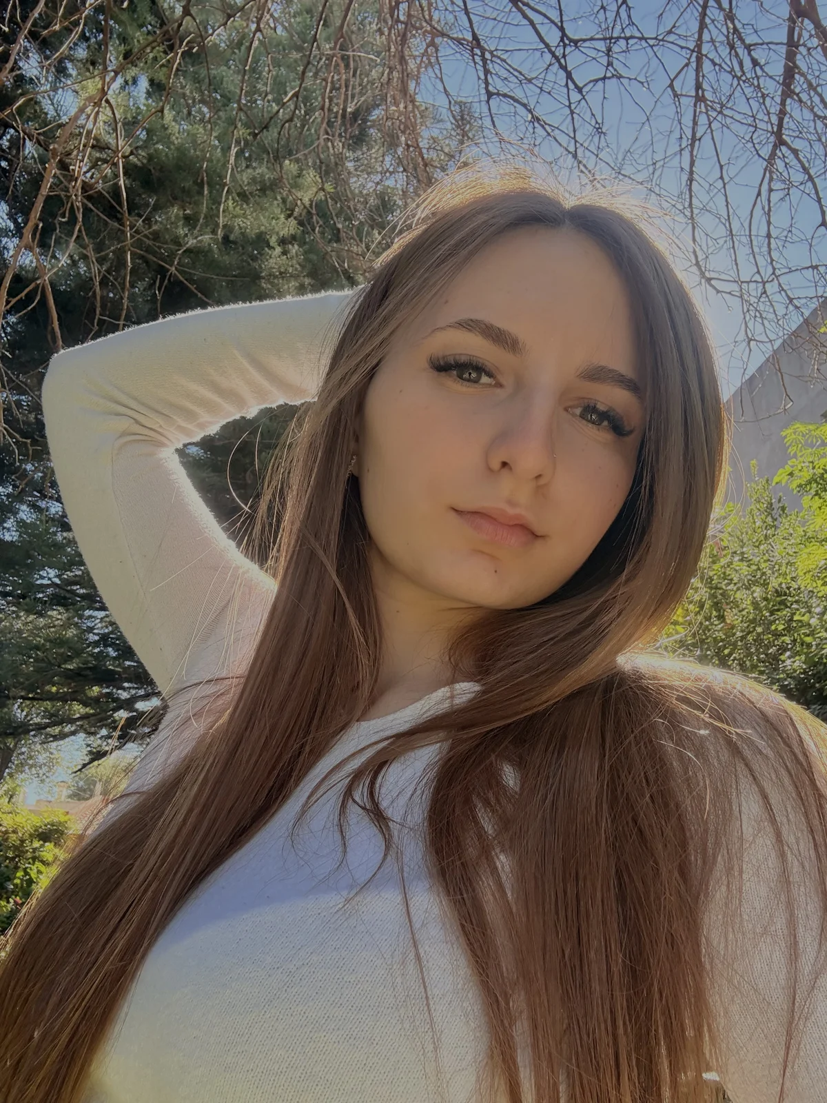 Teya outdoors in the sunshine, wearing a white top